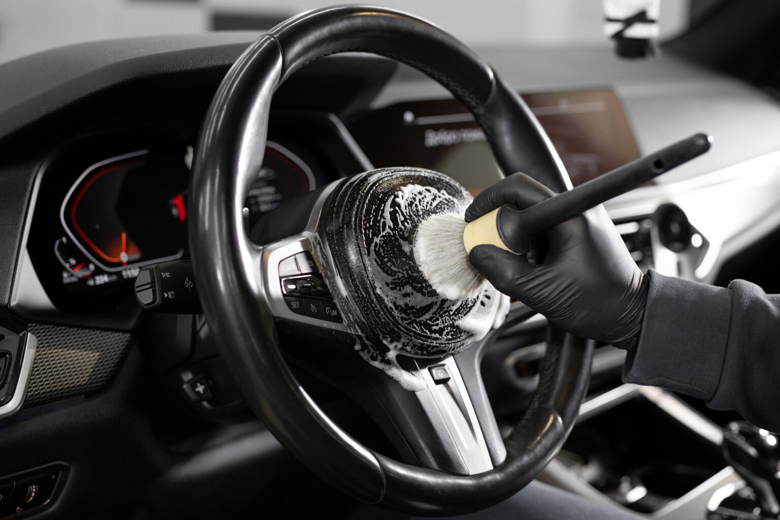 Worker wipes the steering wheel of the car, dry cleaning and interior washing. Detailing studio
